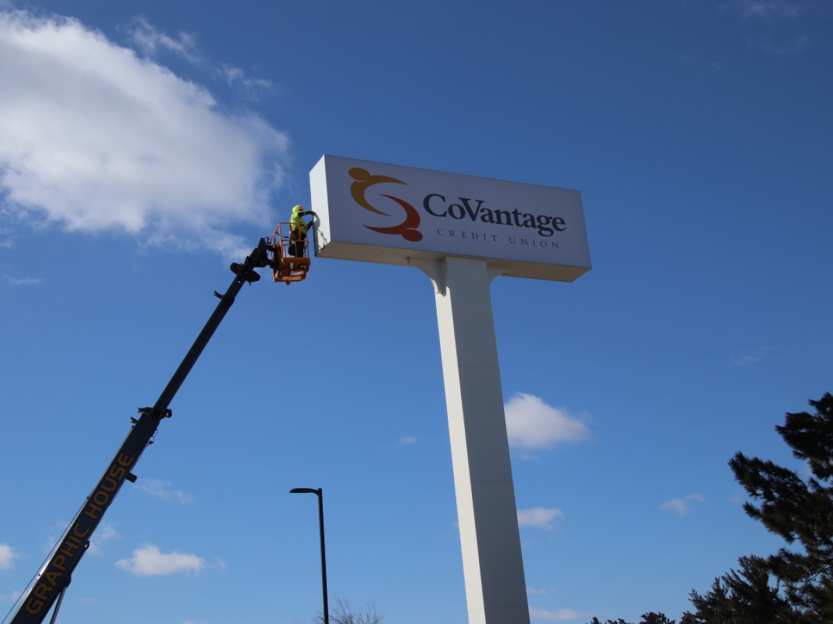 Sign technician performing maintenance for a credit union's signage.